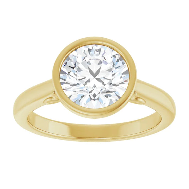 Top view of a 14K yellow gold engagement ring. Center holds a circular indentation for a diamond (bezel set). White background.