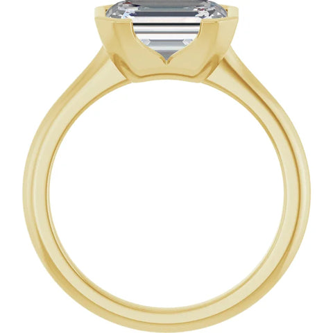 Looking through a 14K yellow gold half bezel engagement ring from the opposite side, showcasing the open space beneath the diamond and the elongated facets of the emerald cut diamond visible through the stone.