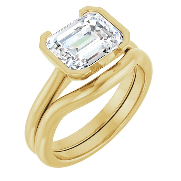 erspective view of a 14K yellow gold emerald cut diamond engagement ring with a half bezel setting. The ring is paired with a simple, polished wedding band in the same yellow gold metal. The rings are stacked together, as if worn on a finger, showcasing how they would look as a set